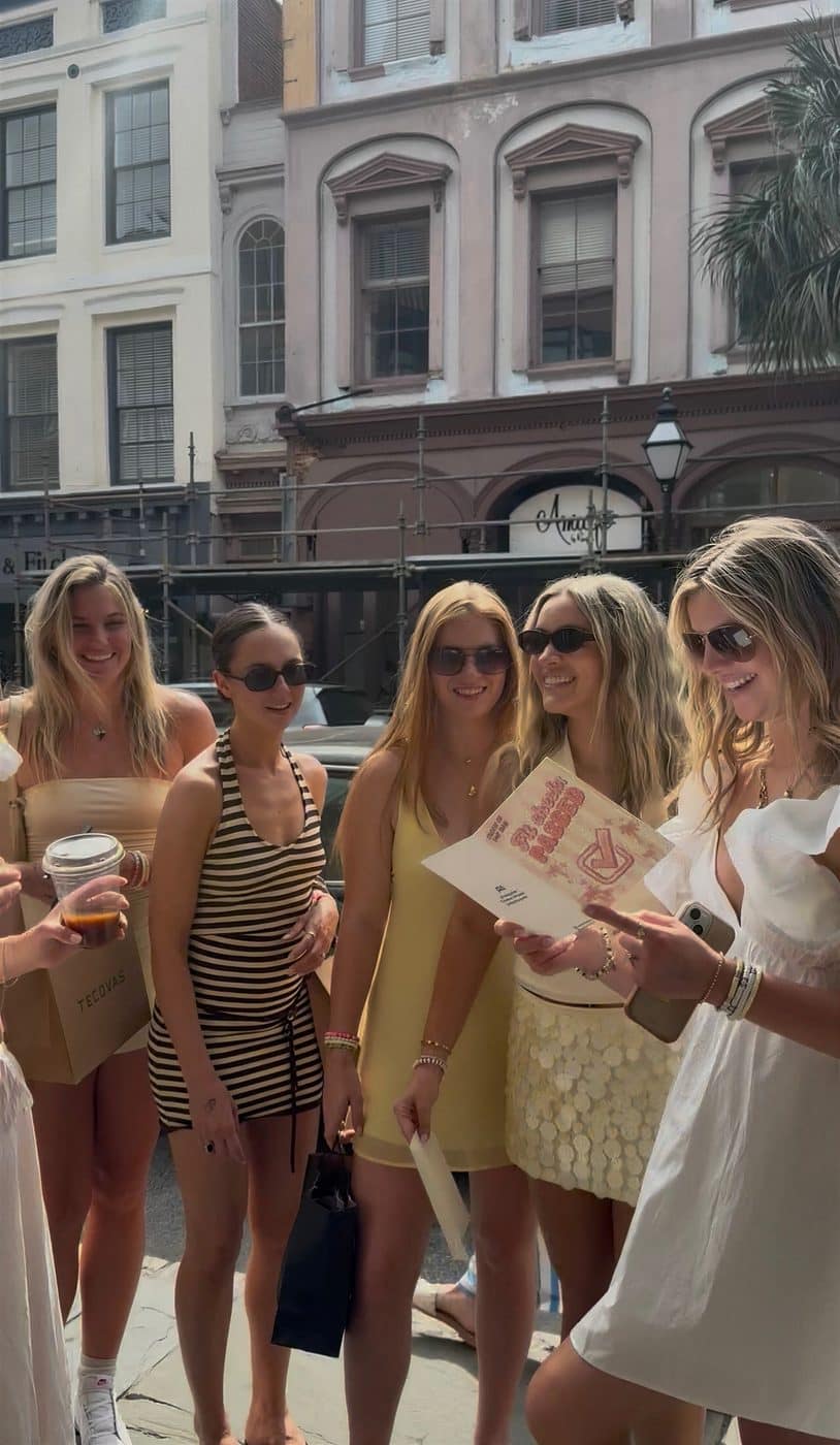 Friends smiling as one holds a P.S. card