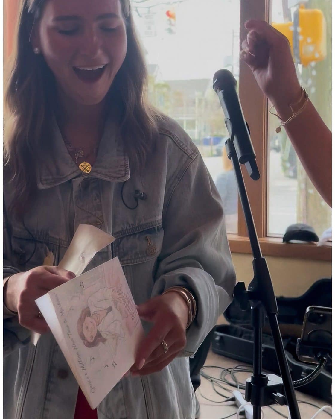 A woman smiling in surprise while reading her card